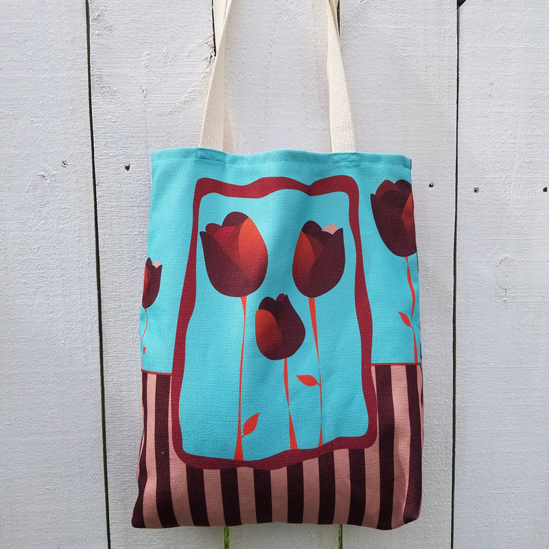 With room for notebooks and a laptop, Reblossom Tote can be so versatile!  A beautiful combination of blue color, stripes, and tulips. - 100% polyester textured canvas withstands everyday use while looking great - Unique design that will never fade. - Cotton webbed 1" straps - Exclusive design by RedButterfly by Omaris